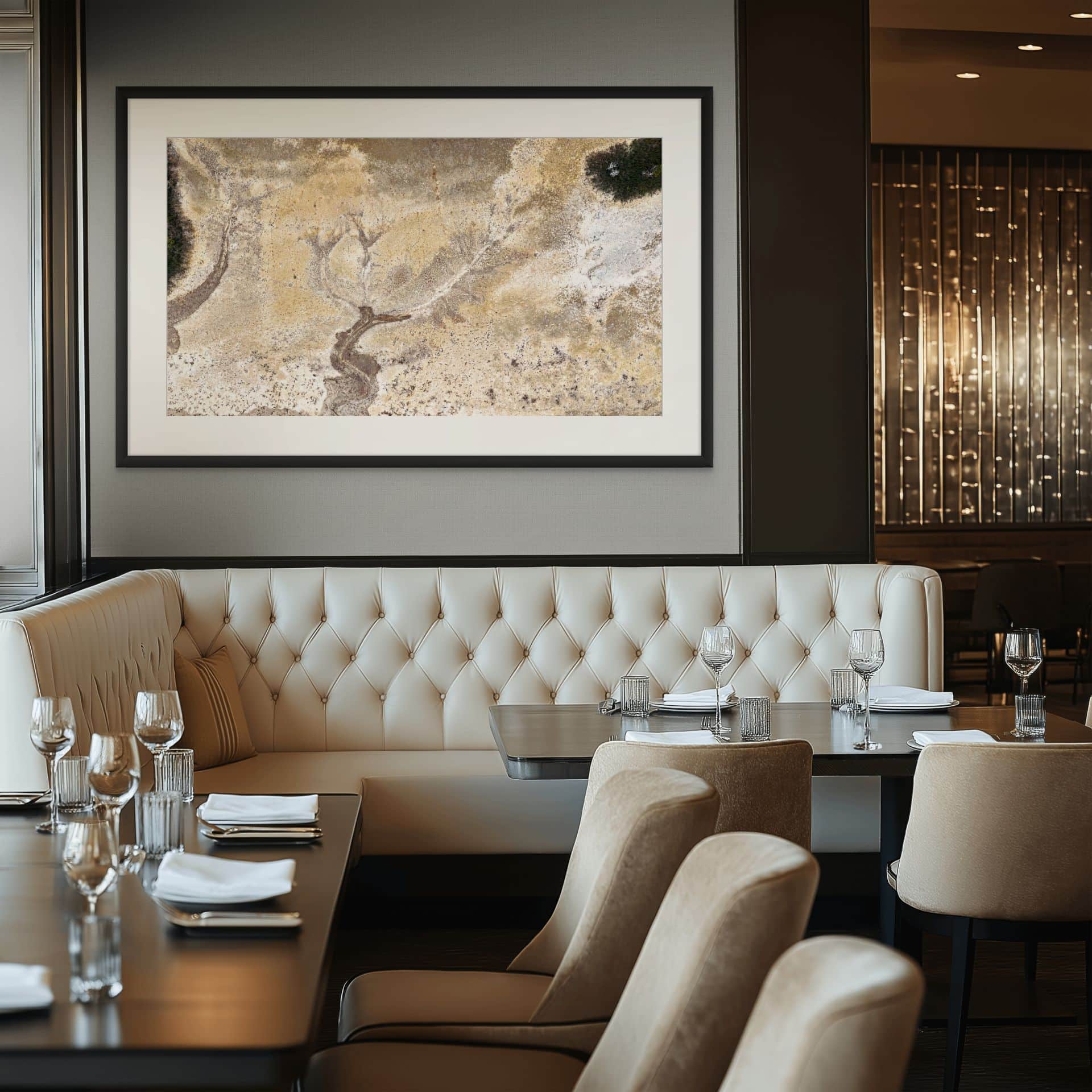 Elegant restaurant interior with cream-coloured tufted banquette seating, neatly set tables, and TENDRIL—a large statement art piece in museum-grade framing—adding sophisticated style to the space. - The Coastal Edit Australia