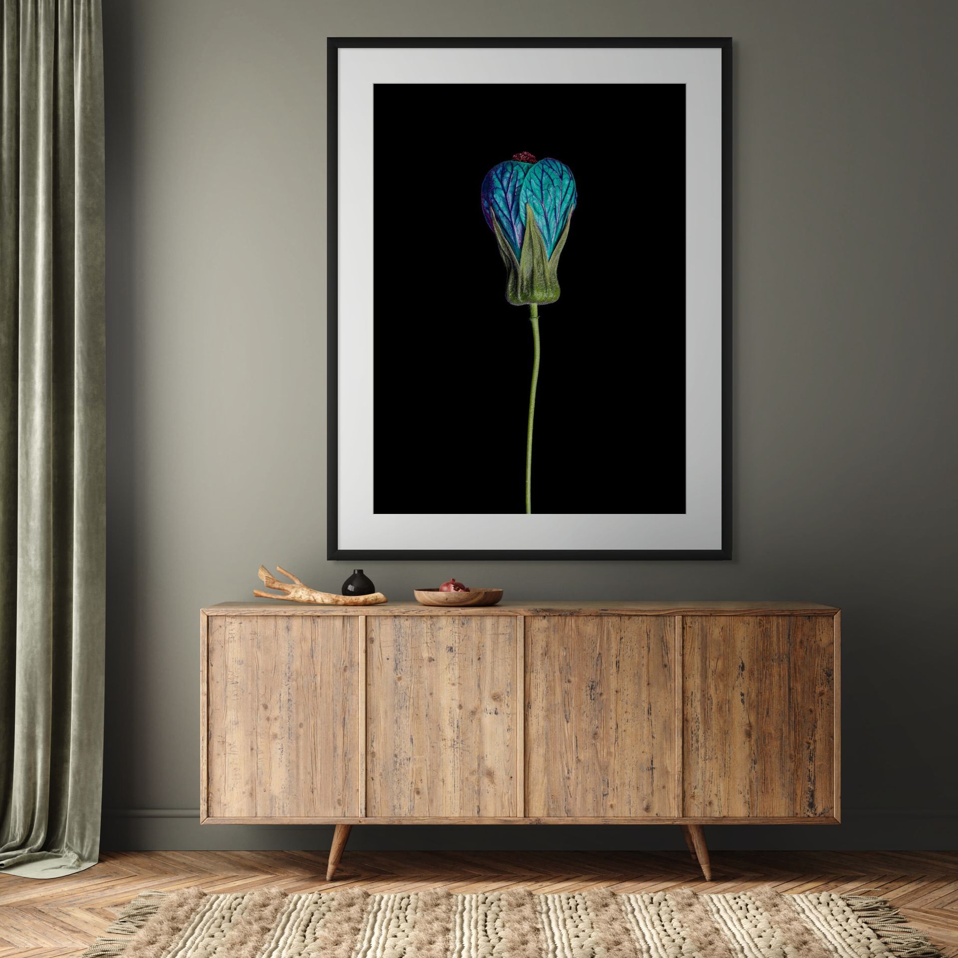 A minimalist room features a wooden sideboard, decorative bowls, and floor-length curtains. Above the sideboard hangs SOLACE—a framed artwork depicting a single blue and purple flower on a black background. - The Coastal Edit Australia