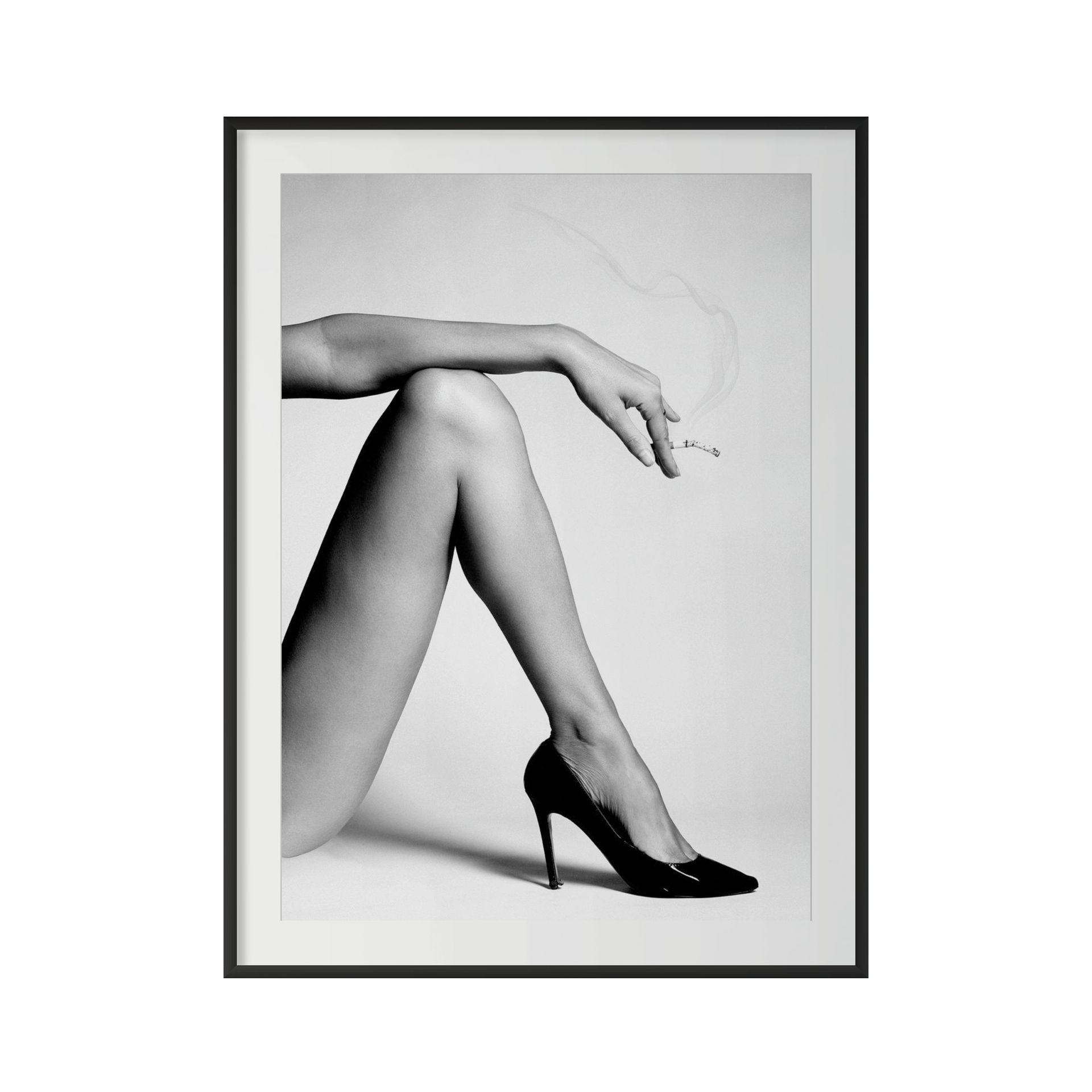 Sure! Here’s a rewritten version of the sentence using your product data: “THE RIGHT is a black and white photograph featuring a woman’s crossed legs in high heels. Her left arm is raised above her, holding a cigarette with smoke trailing upwards. The framed image stands out against a simple, plain background.”. - The Coastal Edit Australia